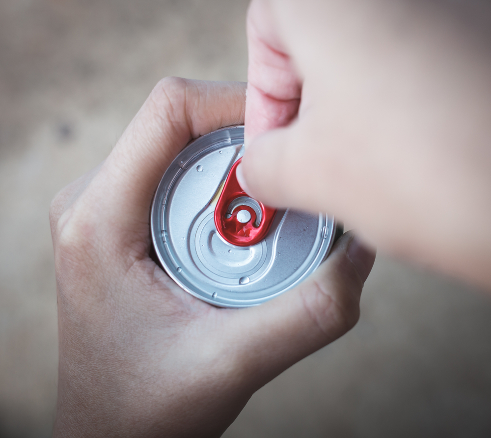 Hand popping the tab on a can of cold brew coffee, coffee beverage innovations