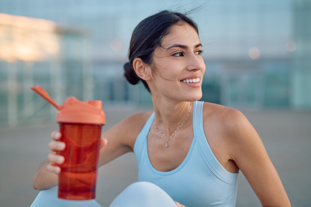 Young Sportswoman Smiling And Holding A Shaker