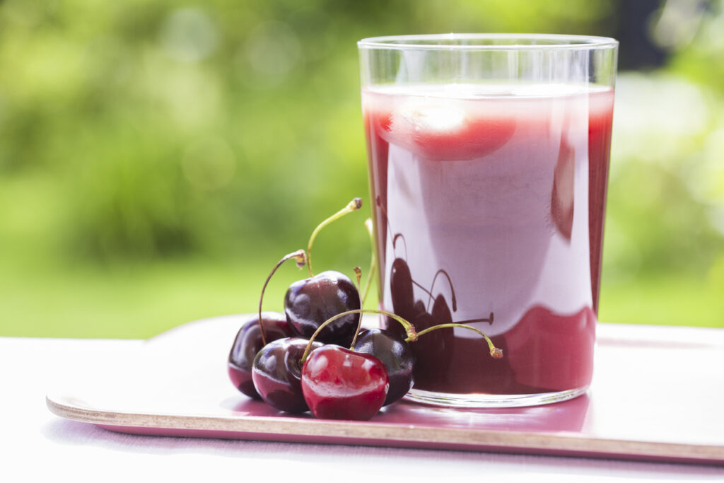 Glass Of Cold Cherry Juice In Garden