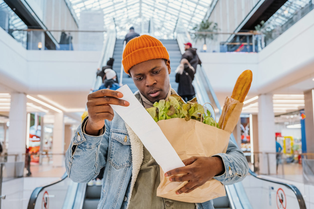 Surprised shopper looking at grocery receipt