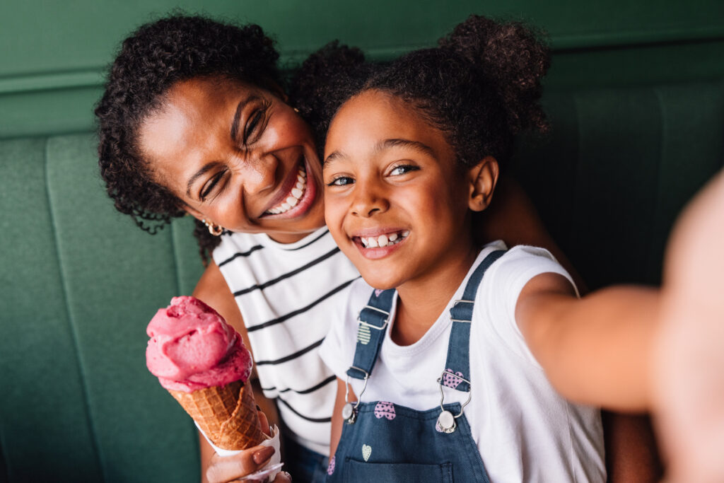 Happy Mother And Daughter Enjoying Ice Cream Together