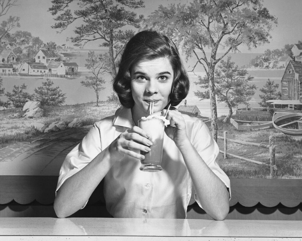 Woman Drinking Ice Cream Soda at a classic American soda fountain